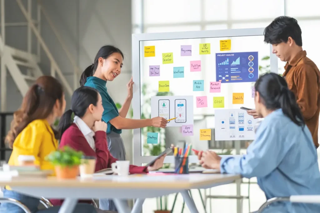 Team mapping an improvement project with sticky notes on a whiteboard